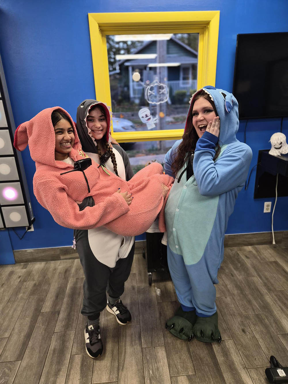 Three girls dressed up in onesies for Halloween